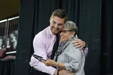 CMU track & field student-athlete Dylan Banagis (left) hugs Pat Podoll after receiving the Pat Podoll Award on Wednesday during the Ferrantino Foundation Academic Excellence Banquet at McGuirk Arena.