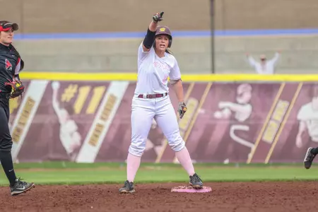 CMU's Danielle Marlink salutes her teammates in the dugout after her two-run double in the fifth inning Friday of the Chippweas' 6-1 victory over Ball State at Margo Jonker Stadium.