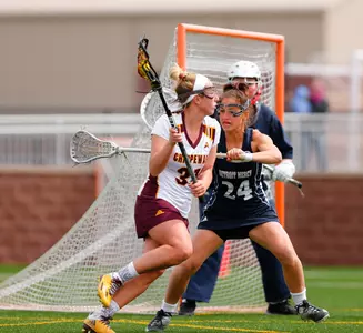 CMU's Riley Huda (left) looks for an open teammate on Saturday during the Chippewas' season-ending 17-12 loss to Detroit Mercy at the CMU Lacrosse-Soccer Stadium.