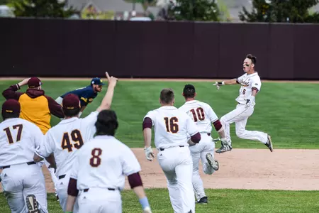Chippewa players rush to mob Alex Borglin (6) after Borglin's two-out, two-run double in the bottom of the ninth lifted the Chippewas to a 4-3 victory over Michigan at Theunissen Stadium.