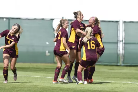 CMU players, including Madison Costner (center), celebrate their 3-2 overtime victory over Oakland on Sunday.
