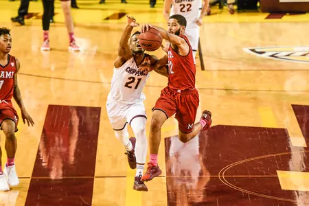 CMU's Cecil Williams (left) races for the ball against Miami's Darrian Ringo on Tuesday at McGuirk Arena.