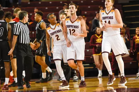 CMU senior Josh Kozinski (12) is congratulated by teammate Shawn Roundtree Jr. during the Chippewas' 81-67 victory over Northern Illinois on Tuesday at McGuirk Arena.