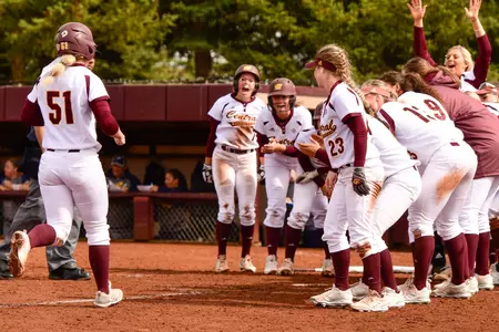Maison Kalina (51) is greeted by her teammates as she arrives at home after her two-run homer in the fifth inning on Friday at Margo Jonker Stadium.