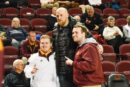 Former CMU great Chris Kaman (center) poses for a photo with fans during a CMU basketball game in 2017-18 at McGuirk Arena.