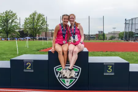 Emily Paupore, Anya Turner pose on the podium after silver and bronze performances in the MAC Steeplechase Championship