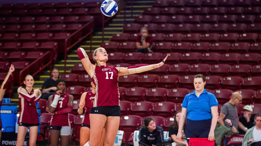 Deanna Dollar serving a volleyball.