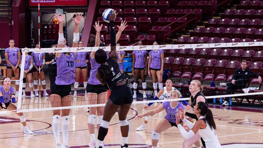Julie Nzambele hitting a ball over the High Point block.