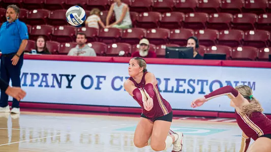 Violet Poole readying to dig a volleyball.