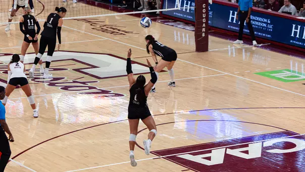 Cole Crews serving a volleyball in TD Arena.