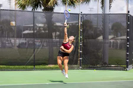 Marra Bruce reaching up to hit the tennis ball