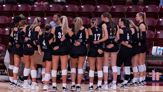Charleston volleyball team huddle during a timeout.