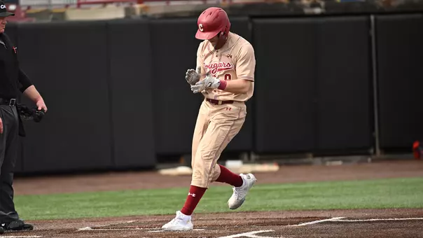 Dylan Johnson clapping his hands as he crosses home plate.