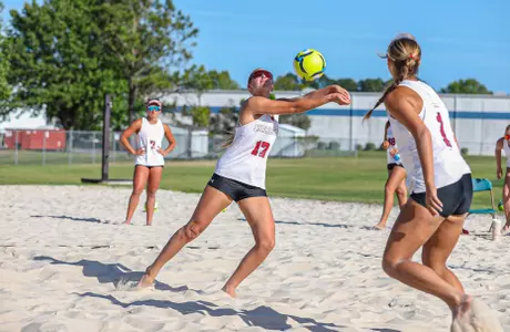 Alivia Newberg reaches for a ball on the beach court