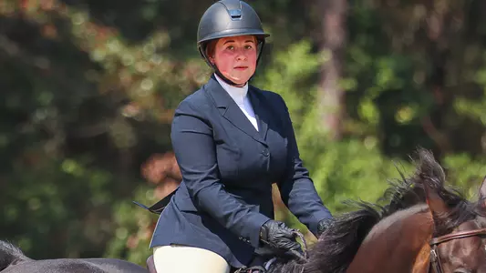 Member of the IHSA equestrian team riding a horse.