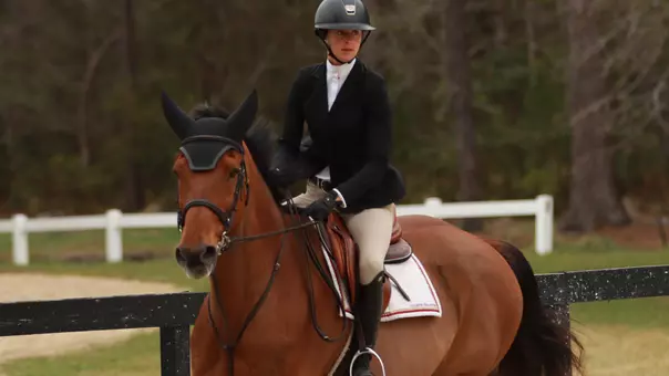 Equestrian student-athlete riding a horse at practice.