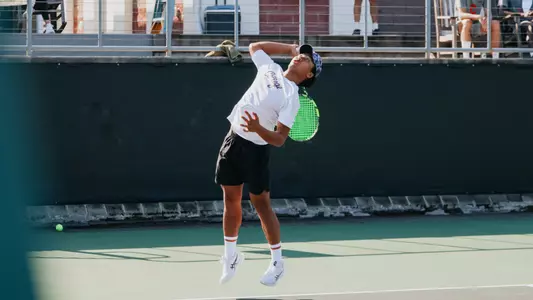 Eddie Vo serves tennis ball