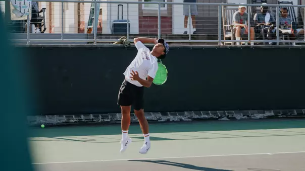 Eddie Vo serves tennis ball