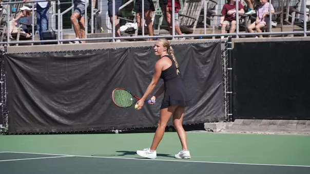 Riley Trinkle serves tennis ball