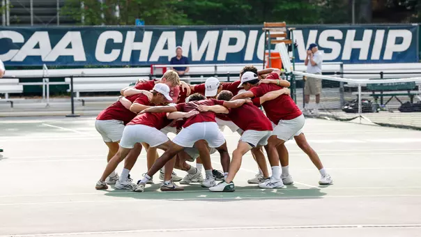 Men's Tennis team huddles at CAA Championship