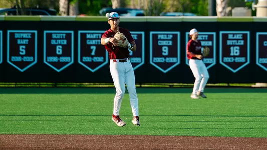 Will Tippett throwing a ball to first base.