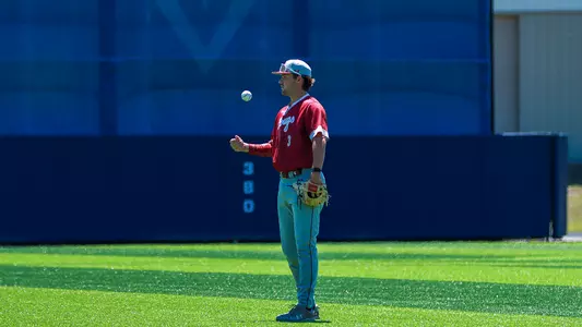 Jake Amman tossing a baseball in the air at UNCW.