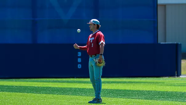 Jake Amman tossing a baseball in the air at UNCW.