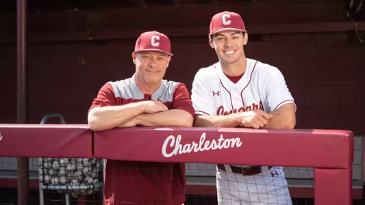 Chad and Reece Holbrook posing for a photo in the dugout at Patriots Point.