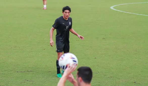 Michiharu Takanashi watching an Elon player throw the ball into play.