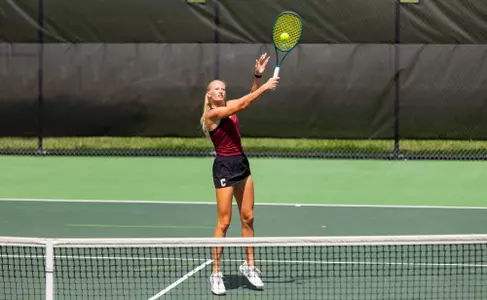 Women's tennis players completes a volley
