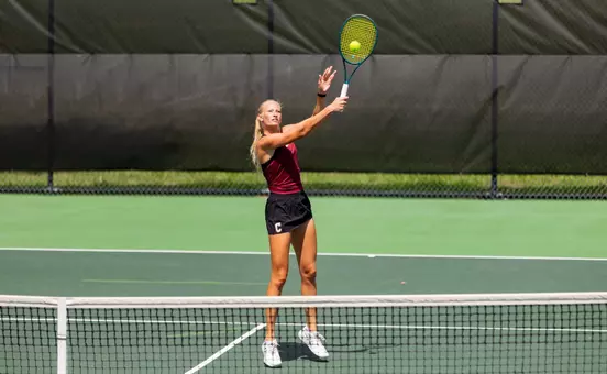 Women's tennis players completes a volley