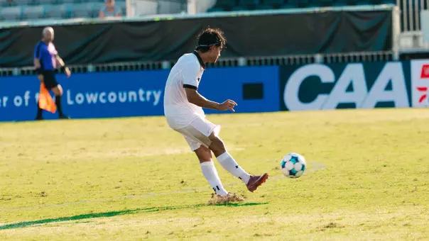 Federico Bellisi kicks soccer ball across pitch