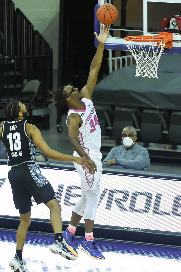 Feb 3, 2021; Omaha, Nebraska, USA; Creighton Bluejays guard Denzel Mahoney (34) scores against Georgetown Hoyas guard Donald Carey (13) in the first half at CHI Health Center Omaha. Mandatory Credit: Steven Branscombe-USA TODAY Sports