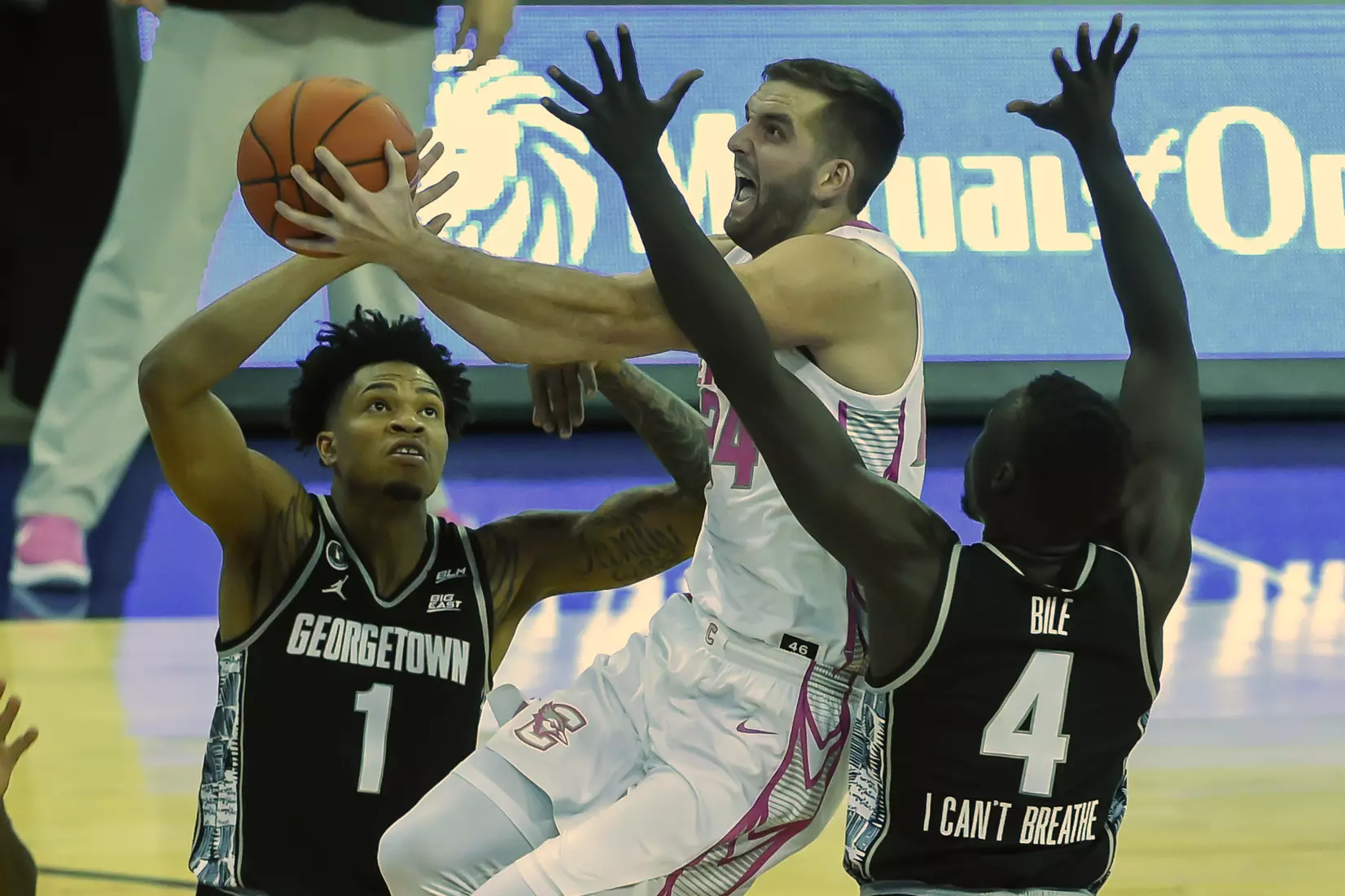Feb 3, 2021; Omaha, Nebraska, USA; Creighton Bluejays guard Mitch Ballock (24) scores between Georgetown Hoyas forward Jamorko Pickett (1) and forward Chudier Bile (4) in the second half at CHI Health Center Omaha. Mandatory Credit: Steven Branscombe-USA TODAY Sports
