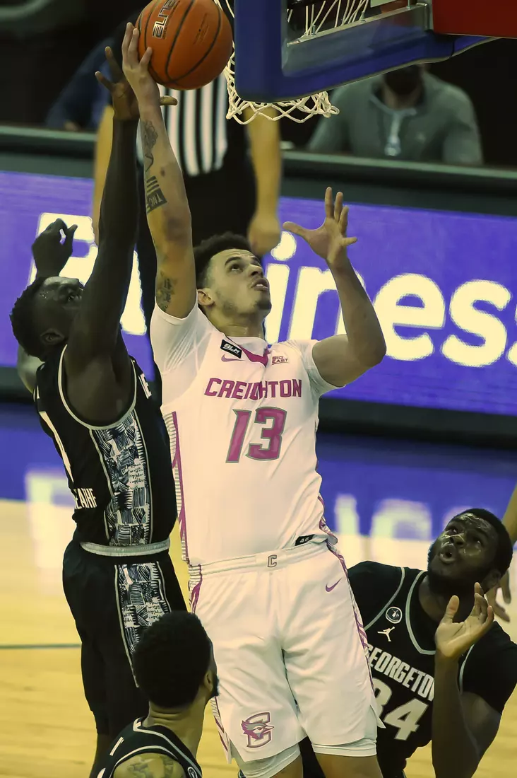 Feb 3, 2021; Omaha, Nebraska, USA; Creighton Bluejays forward Christian Bishop (13) shoots over Georgetown Hoyas forward Chudier Bile (4) and guard Denzel Mahoney (34) in the second half at CHI Health Center Omaha. Mandatory Credit: Steven Branscombe-USA TODAY Sports