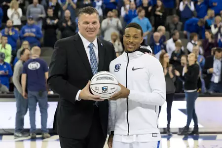 Marcus Foster is honored by Greg McDermott with a ball in reconigition of his 2,000 career point