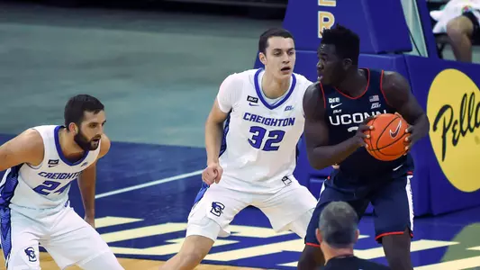Jan 23, 2021; Omaha, Nebraska, USA;  Connecticut Huskies forward Adama Sanogo (21) drives against Creighton Bluejays center Ryan Kalkbrenner (32) and guard Mitch Ballock (24) in the first half at CHI Health Center Omaha. Mandatory Credit: Steven Branscombe-USA TODAY Sports