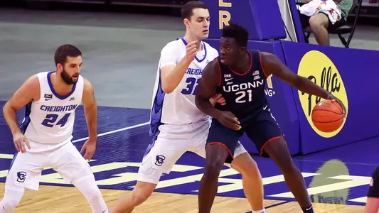Jan 23, 2021; Omaha, Nebraska, USA;  Connecticut Huskies forward Adama Sanogo (21) backs in against Creighton Bluejays center Ryan Kalkbrenner (32) and guard Mitch Ballock (24) in the first half at CHI Health Center Omaha. Mandatory Credit: Steven Branscombe-USA TODAY Sports