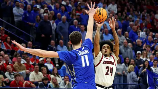Mar 20, 2025; Lexington, KY, USA; Louisville Cardinals guard Chucky Hepburn (24) shoots the ball again Creighton Bluejays center Ryan Kalkbrenner (11) in the first round of the NCAA Tournament at Rupp Arena. Mandatory Credit: Jordan Prather-Imagn Images