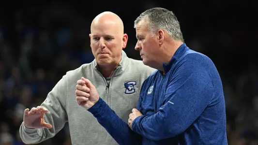 Dec 30, 2025; Omaha, Nebraska, USA; Creighton Bluejays head coach Greg McDermott and assistant coach Alan Huss talk during a break in the game against the Butler Bulldogs during the second half at CHI Health Center Omaha. Mandatory Credit: Steven Branscombe-Imagn Images