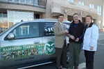 Athletic Director Paul Kowalczyk presents the keys to a new Saab 9-7x, won by Darrell and Deon Hailey from Timberline Church