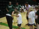 Members of the CSU golf team help a young fan with the art of putting Tuesday
