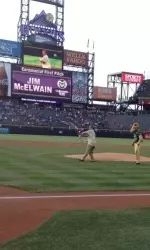 Jim McElwain throws the first pitch at Coors Field.