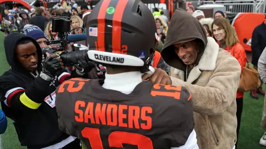 NFL legend Deion Sanders, right, gives his son Shedeur Sanders a pep talk before an NFL football game at Huntington Bank Field, Dec. 7, 2025, in Cleveland, Ohio.