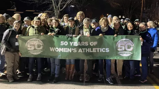 Alumnae marching in Dartmouth night to celebrate 50 years of women's athletics, Oct. 28, 2022