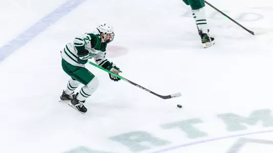 Ian Pierce skates with the puck up the ice