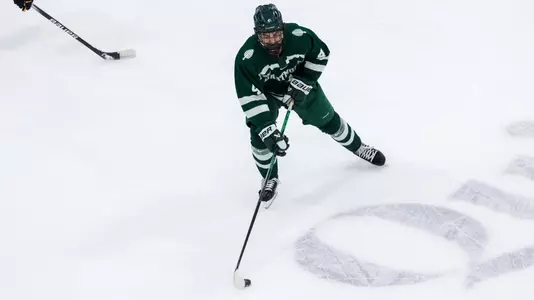 CJ Foley skates the puck up against Qu