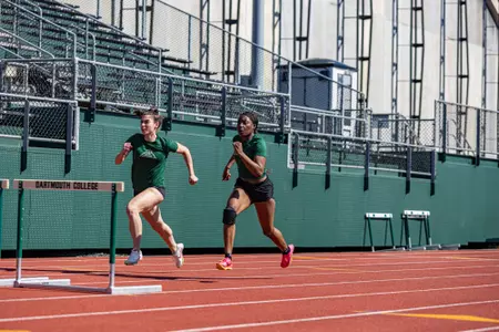 Athletes practicing their outdoor hurdles