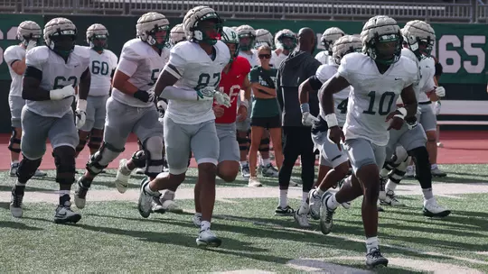Football Players running on field