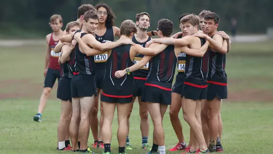 Photo of the men's cross country team in a huddle